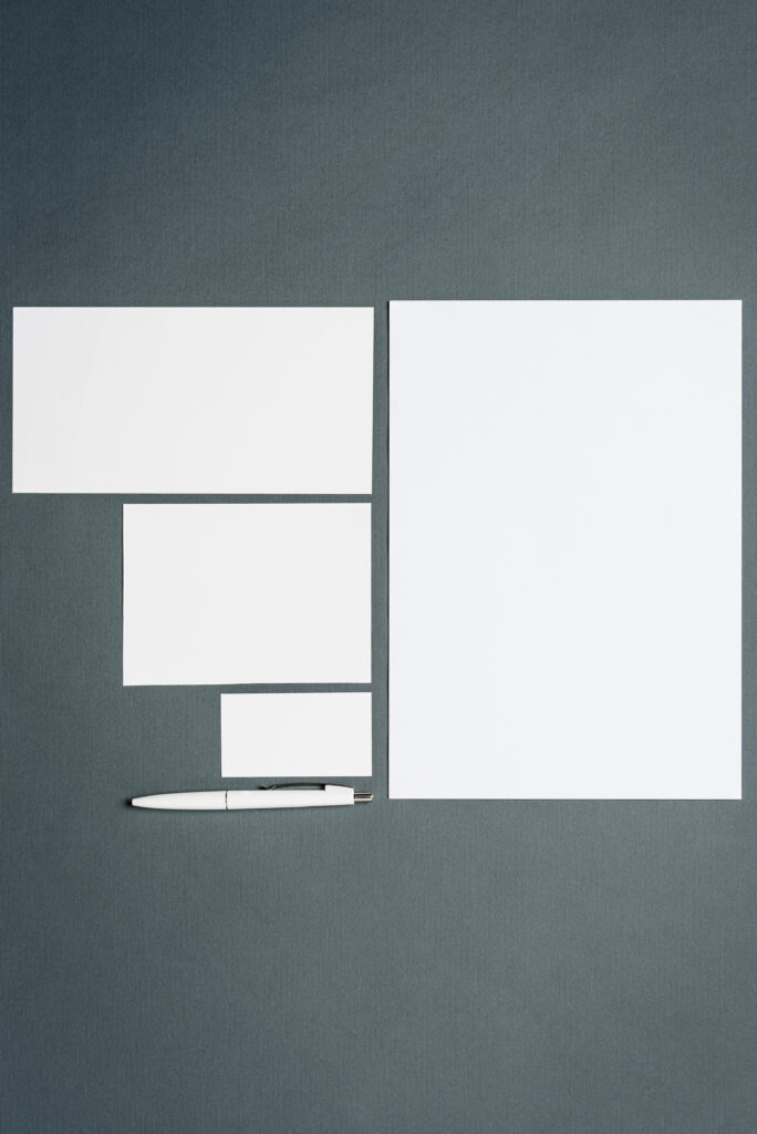 Mock-up business template with cards, papers, pen on gray background.